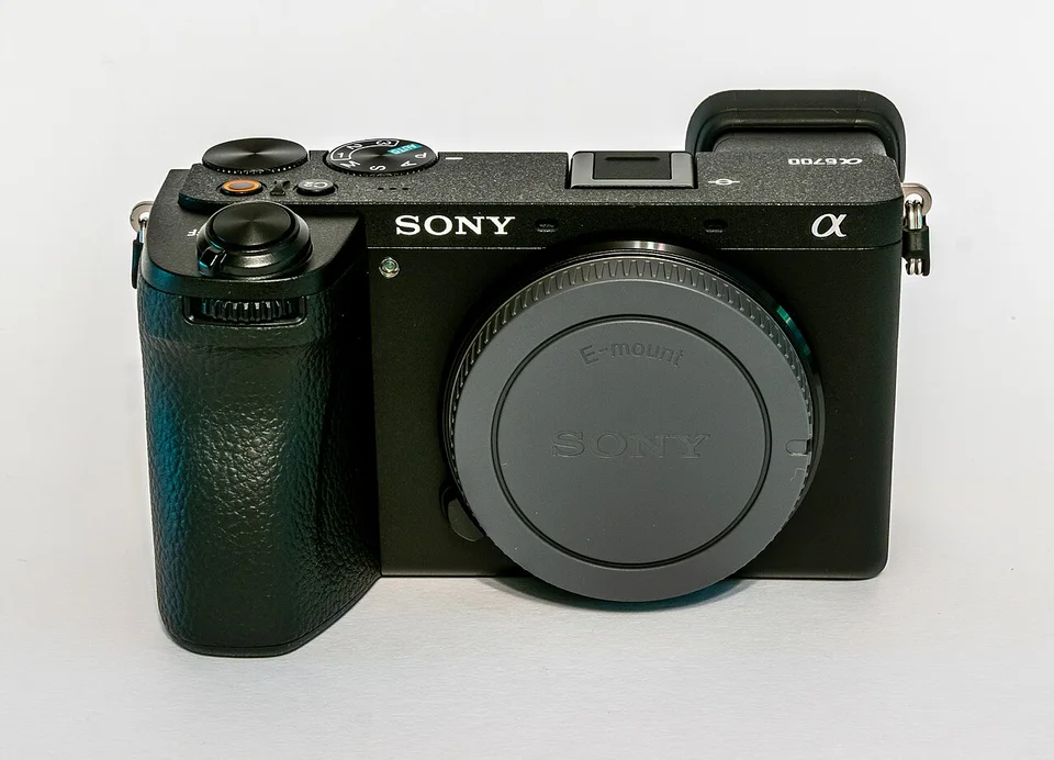 Sony a6700 camera body with an E-mount body cap on a white background